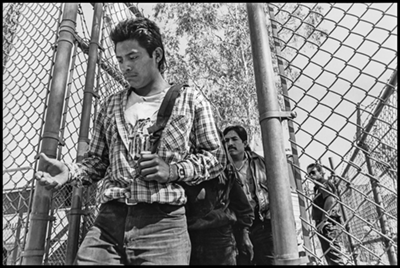 A worker is deported back into Mexico at the border gate in Mexicali, under the baleful stare of a Border Patrol agent.